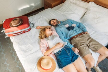 Travelers sitting on a hotel bed looking at a map and planning their Louisiana stay